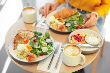 Fresh breakfast plates and lattes on a cafe table at a breakfast cafe near you in Wisconsin
