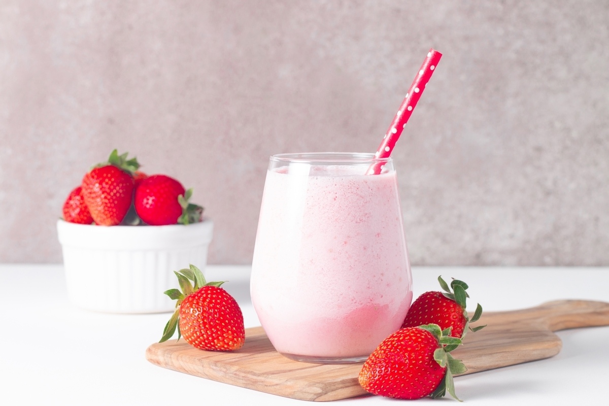 Smoothie in Verona WI served in a clear glass with fresh strawberries and a red straw at Icki Sticki cafe